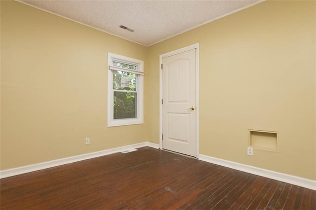 empty room with a textured ceiling and hardwood / wood-style floors