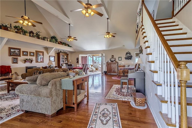 living room featuring dark hardwood / wood-style flooring, high vaulted ceiling, and ceiling fan