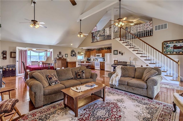 living room featuring ceiling fan, hardwood / wood-style floors, and high vaulted ceiling