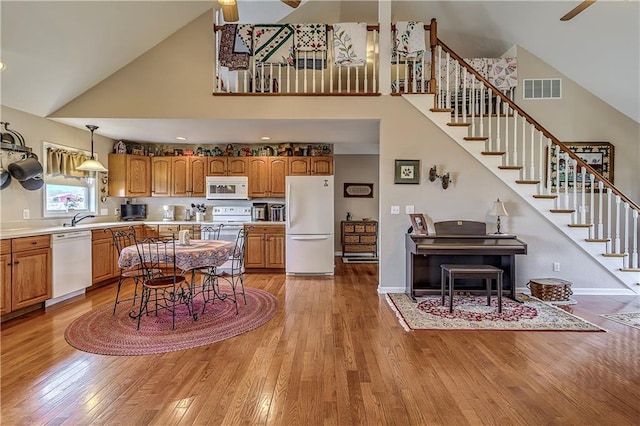 interior space featuring high vaulted ceiling, light hardwood / wood-style flooring, sink, and ceiling fan