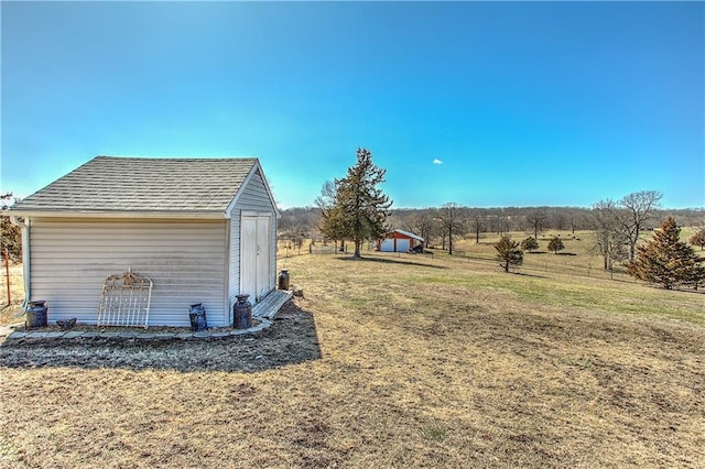 view of yard featuring a rural view and a storage shed