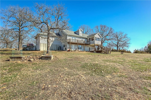 back of property featuring a wooden deck and a lawn