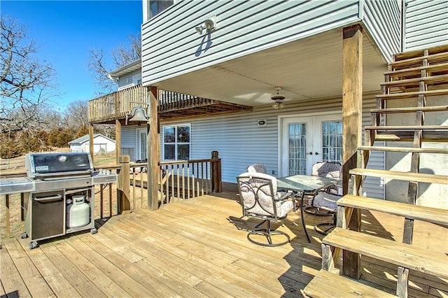 wooden terrace featuring a grill, ceiling fan, and french doors