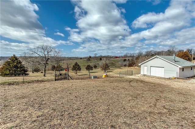 view of yard with an outbuilding, a rural view, and a garage