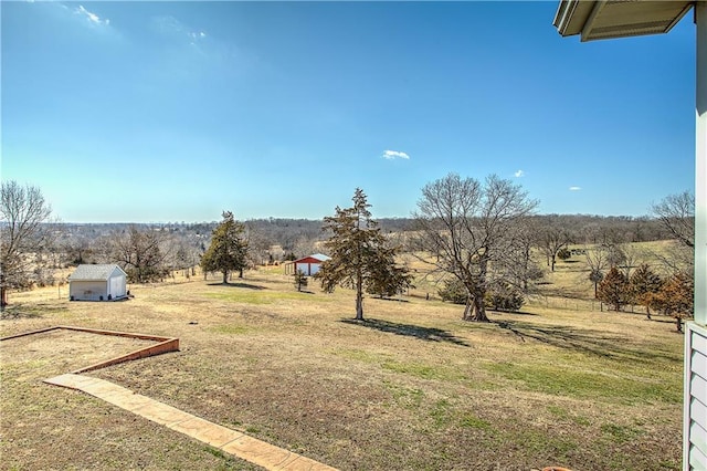 view of yard featuring a rural view and a shed