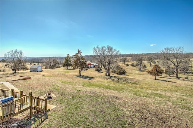 view of yard featuring a rural view and a storage shed