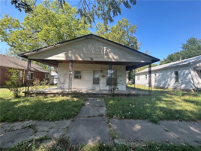 bungalow with covered porch and a front lawn