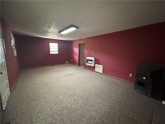 interior space featuring a textured ceiling, radiator, carpet floors, and heating unit