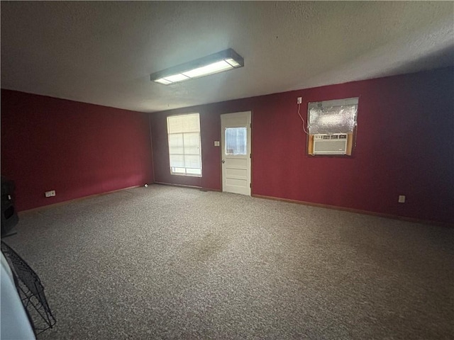 unfurnished room with a textured ceiling, cooling unit, and carpet floors