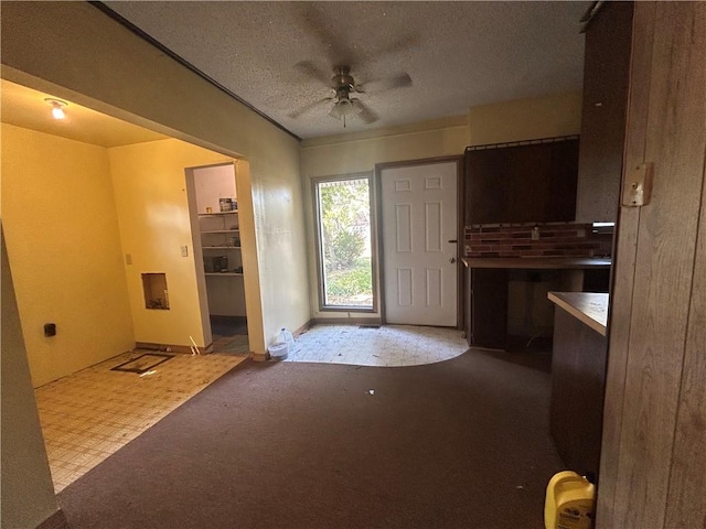 foyer featuring a textured ceiling, carpet flooring, and ceiling fan