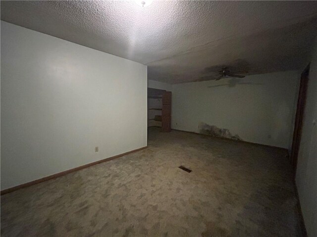 carpeted empty room featuring a textured ceiling and ceiling fan