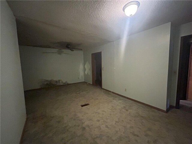 unfurnished room with a textured ceiling, carpet flooring, and ceiling fan