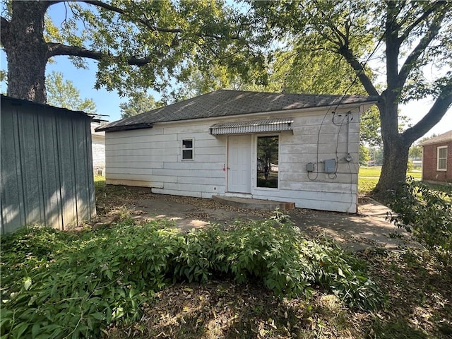 back of house featuring a storage shed