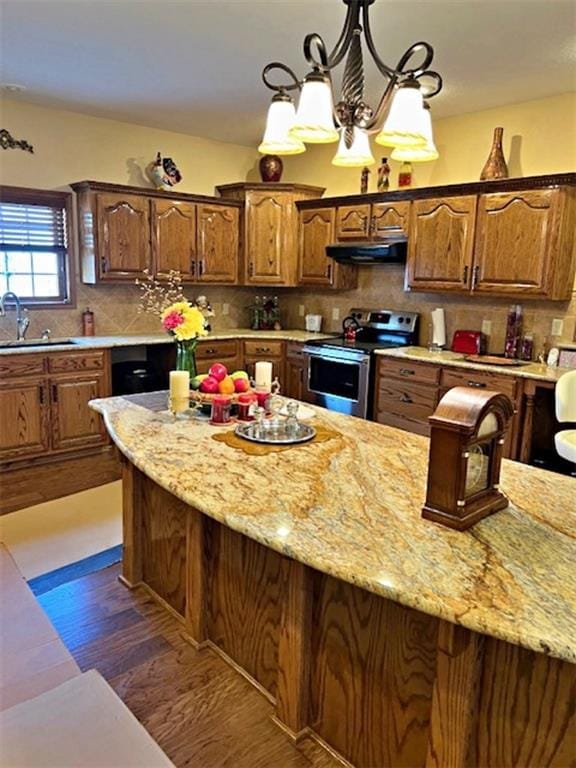 kitchen featuring an inviting chandelier, electric stove, sink, dark hardwood / wood-style floors, and tasteful backsplash