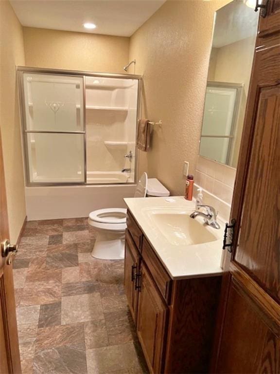 full bathroom with shower / bath combination with glass door, vanity, and toilet