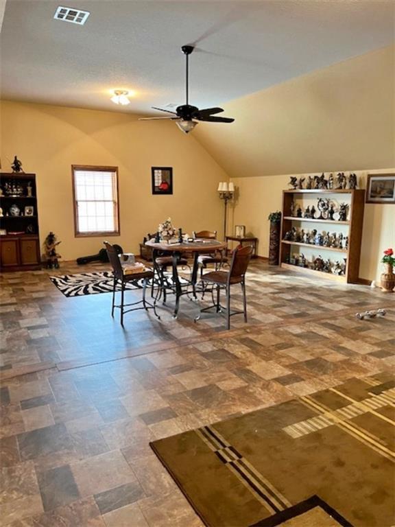 dining space featuring ceiling fan and lofted ceiling