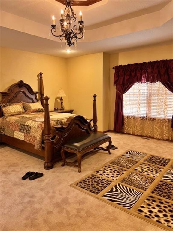 carpeted bedroom featuring an inviting chandelier and a raised ceiling