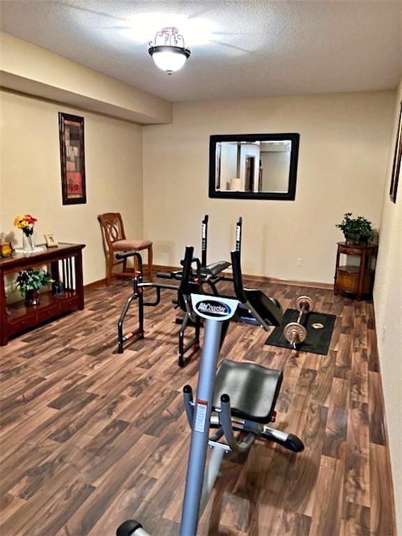 workout room with a textured ceiling and dark hardwood / wood-style floors