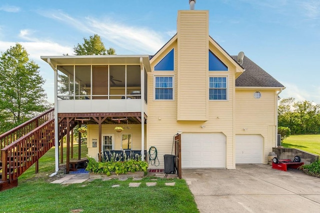 exterior space featuring a garage, a sunroom, and a yard