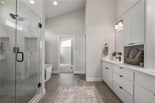 bathroom with lofted ceiling, independent shower and bath, and vanity