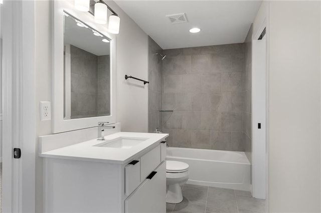 full bathroom featuring vanity, tiled shower / bath combo, and toilet