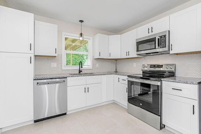 kitchen with backsplash, stainless steel appliances, white cabinetry, and sink