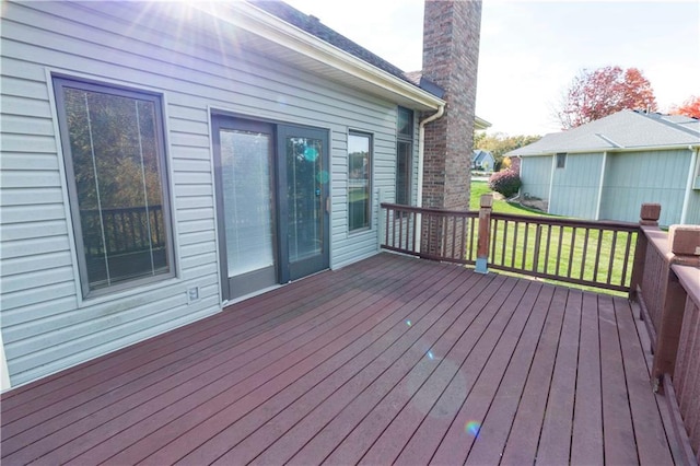 wooden deck featuring a lawn