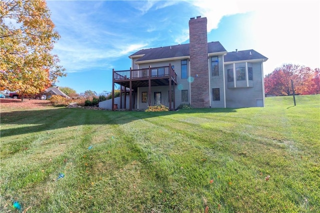 rear view of house featuring a wooden deck and a yard