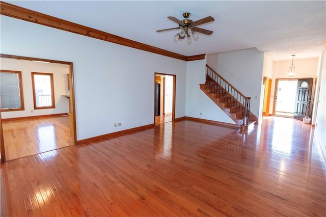 unfurnished living room featuring crown molding, hardwood / wood-style flooring, and ceiling fan