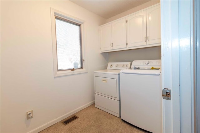 washroom featuring light carpet, separate washer and dryer, and cabinets