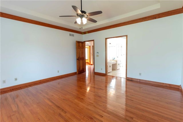 spare room featuring crown molding, light wood-type flooring, and ceiling fan