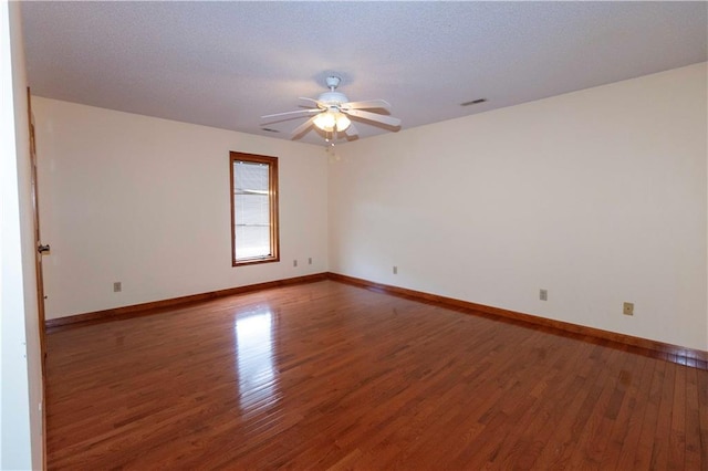 empty room featuring a textured ceiling, ceiling fan, and dark hardwood / wood-style flooring