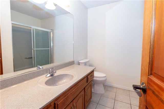 bathroom with vanity, a shower with shower door, toilet, and tile patterned floors