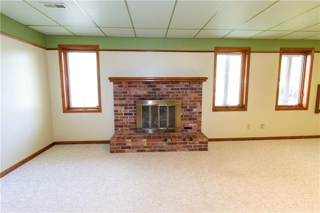 unfurnished living room with carpet, a paneled ceiling, and plenty of natural light