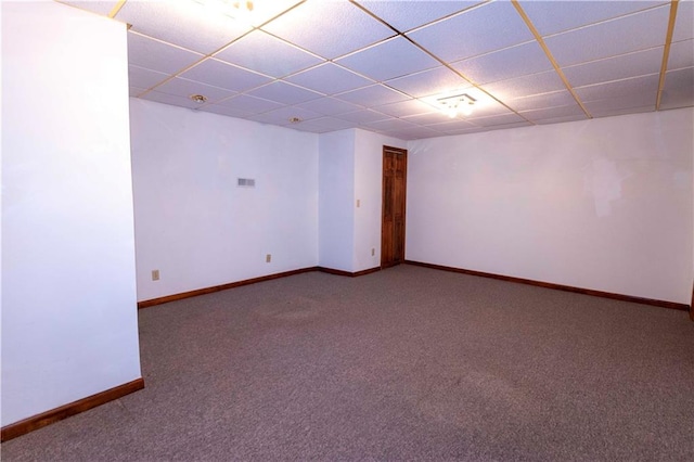 empty room with carpet flooring and a paneled ceiling