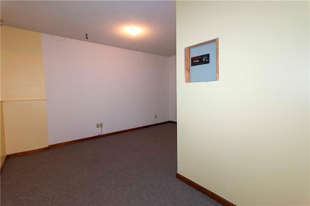 carpeted empty room featuring a textured ceiling