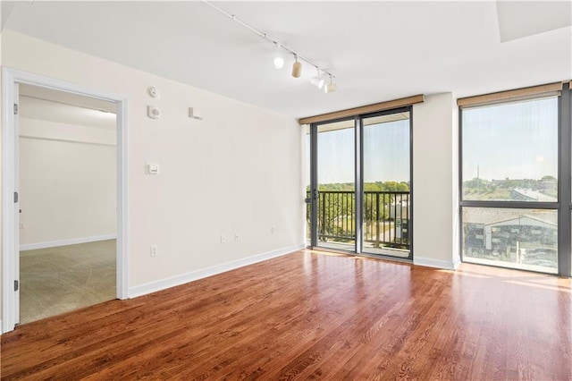 spare room featuring hardwood / wood-style floors and rail lighting