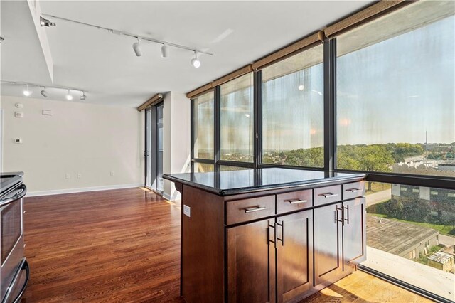 600 E Admiral Blvd Unit 704, Kansas City, MO 64106 - kitchen with rail lighting, stove, wood finished floors, dark countertops, and dark brown cabinetry