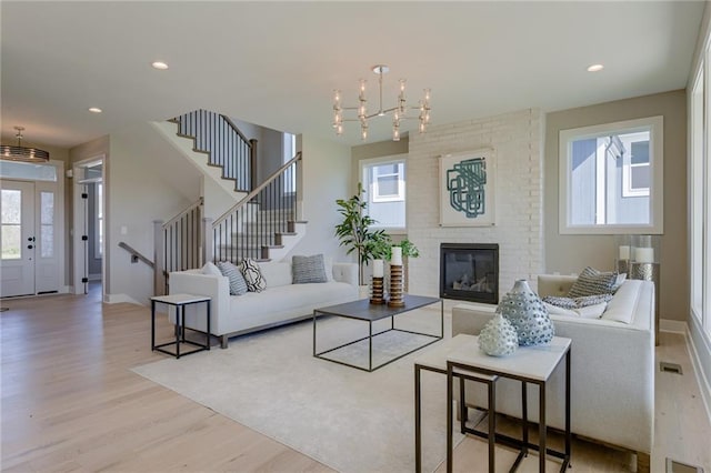 living room with light wood-type flooring and a large fireplace