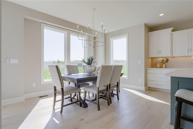 dining space with a chandelier, light hardwood / wood-style floors, and a healthy amount of sunlight