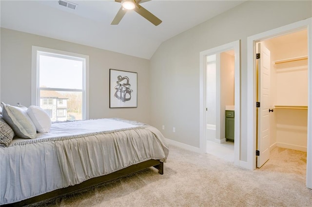 carpeted bedroom with ensuite bathroom, lofted ceiling, a closet, a spacious closet, and ceiling fan