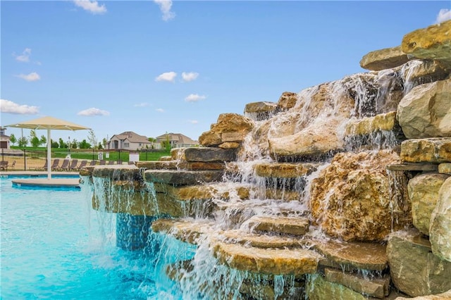 view of swimming pool with pool water feature