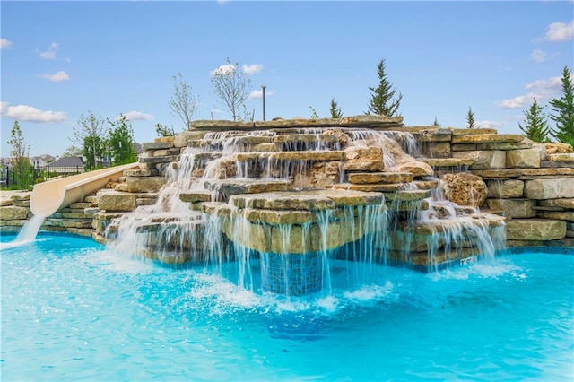 view of swimming pool with pool water feature