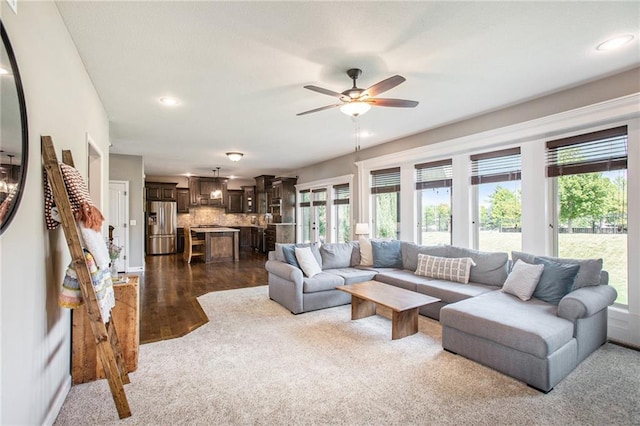 living room with ceiling fan and dark wood-type flooring