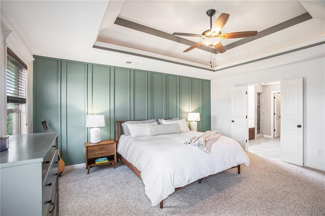 carpeted bedroom featuring a raised ceiling and ceiling fan