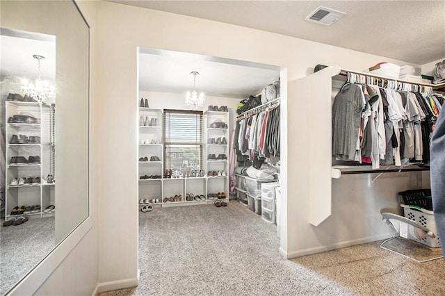 walk in closet with carpet and a chandelier