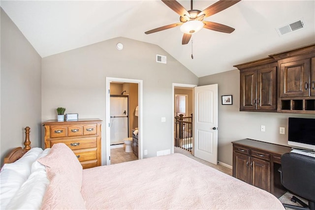 bedroom with ceiling fan, built in desk, ensuite bathroom, light colored carpet, and vaulted ceiling