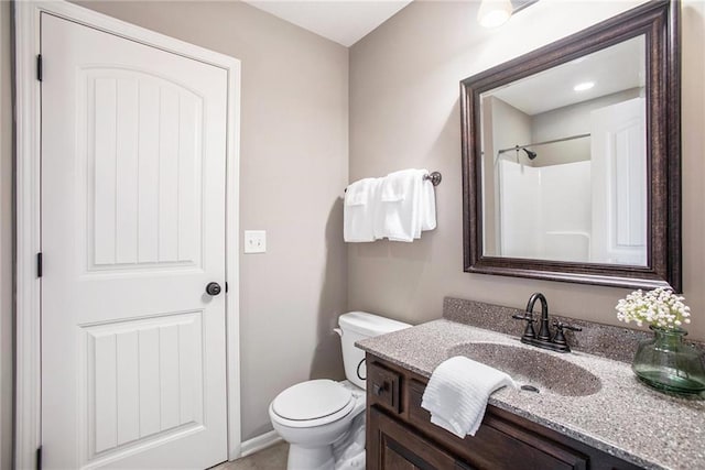 bathroom with walk in shower, vanity, and toilet