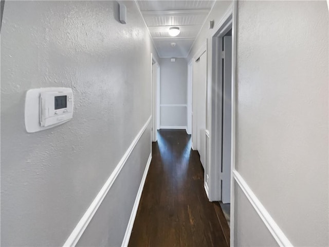 hallway featuring a textured wall and wood finished floors