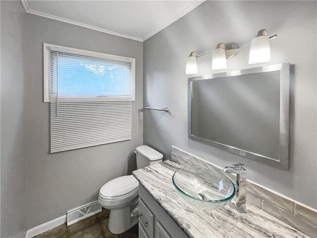 half bathroom with visible vents, baseboards, toilet, ornamental molding, and vanity